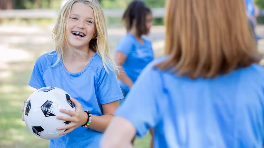 Girl Playing Soccer During Braces Treatment