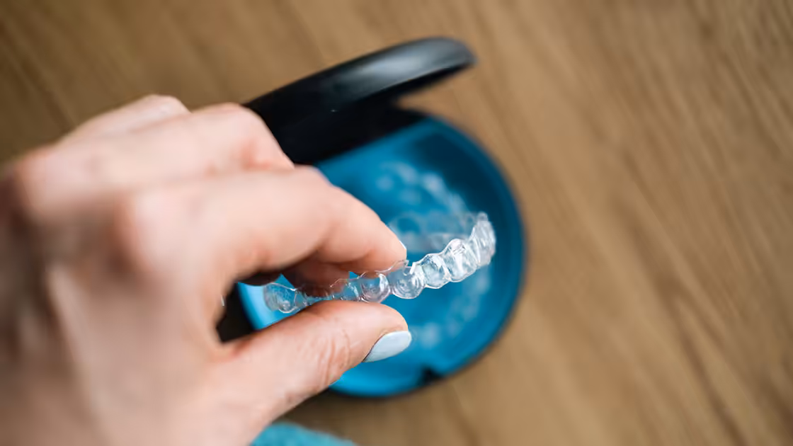 Patient holds clear aligners