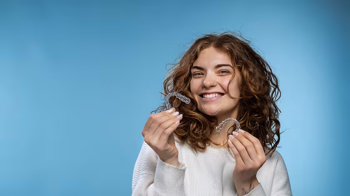 Patient holding orthodontic retainers